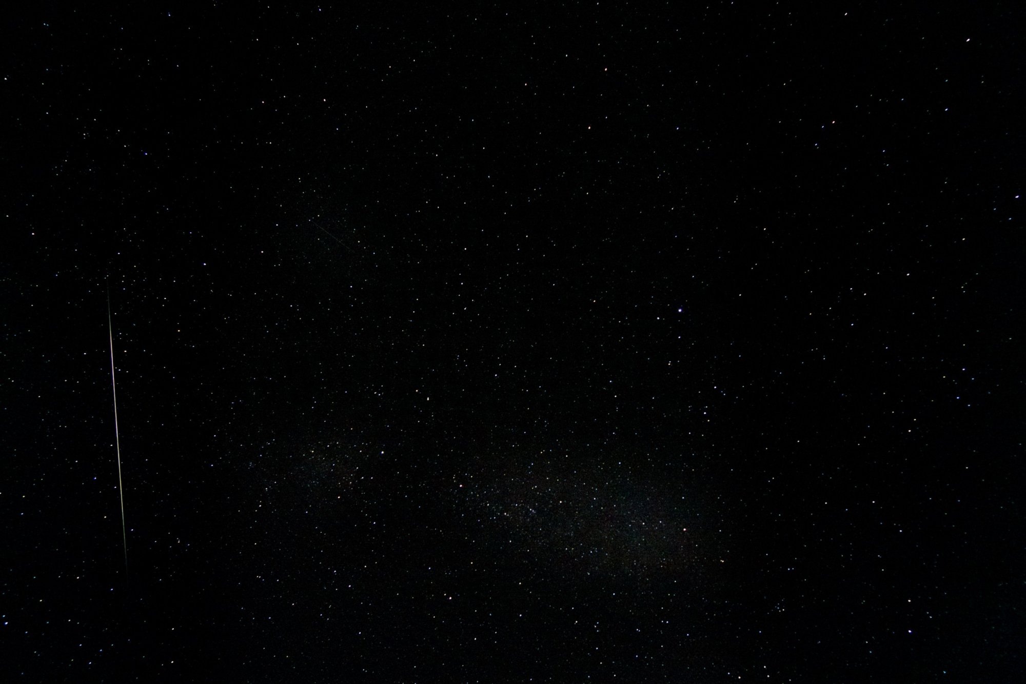 A bright meteor streak beside the faint band of the Milky Way over Ithaca, New York